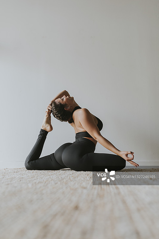 闭着眼睛在工作室练习瑜伽的女讲师图片素材