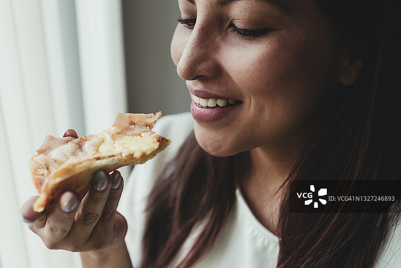 在家吃披萨的微笑女人图片素材