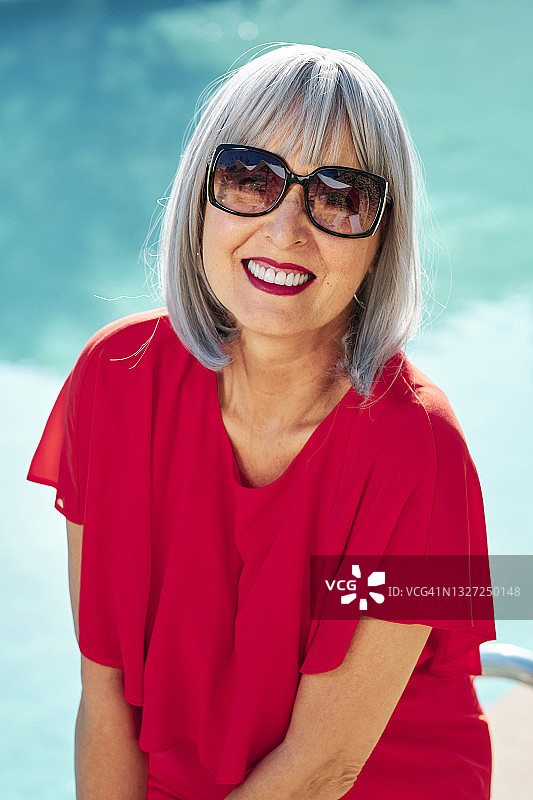 在阳光明媚的日子里戴着太阳镜的微笑中年妇女图片素材