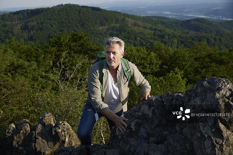 背着背包爬山的中年男人图片素材