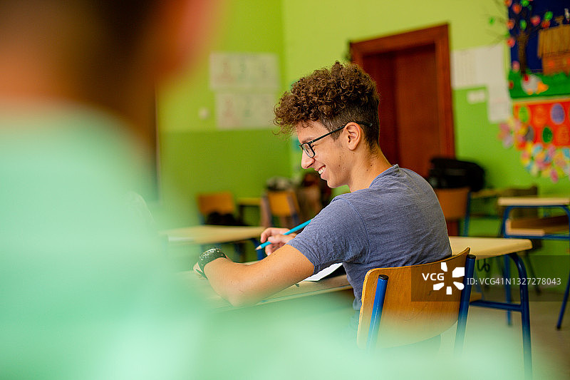 男孩微笑地做测试题图片素材