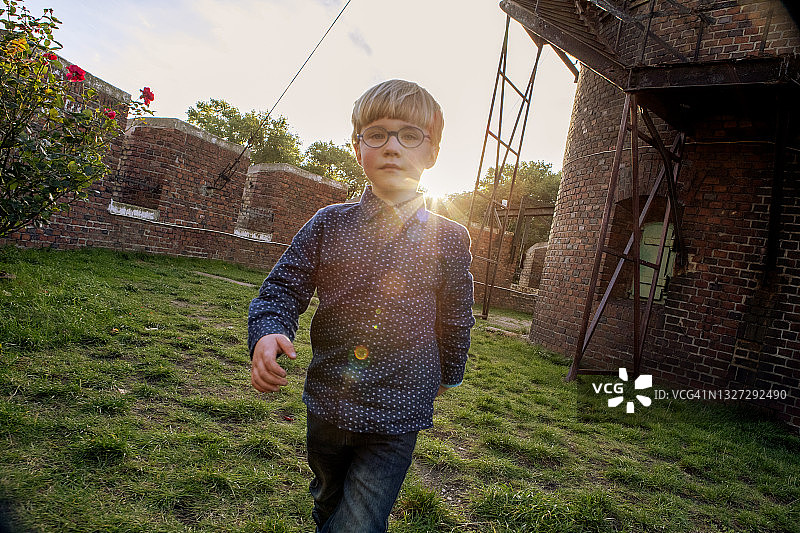 在城堡的傍晚灯光中行走的小男孩图片素材