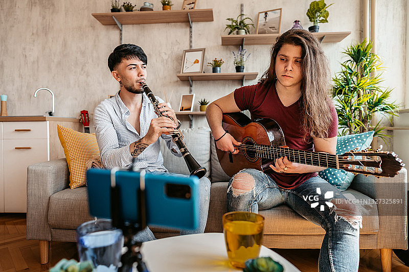 两个男人在家中制作单簧管和吉他演奏教程图片素材