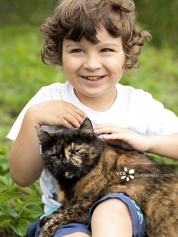 快乐微笑的儿童与猫玩耍图片素材
