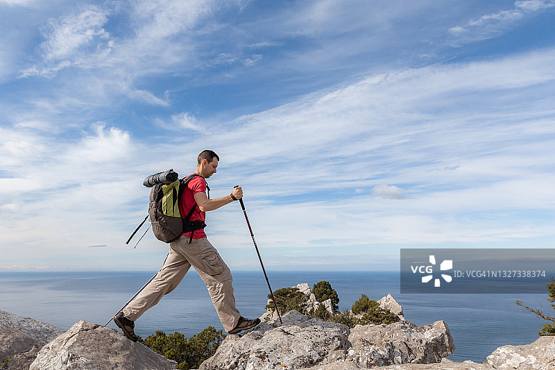 在山中拄着登山杖行走的背包客图片素材