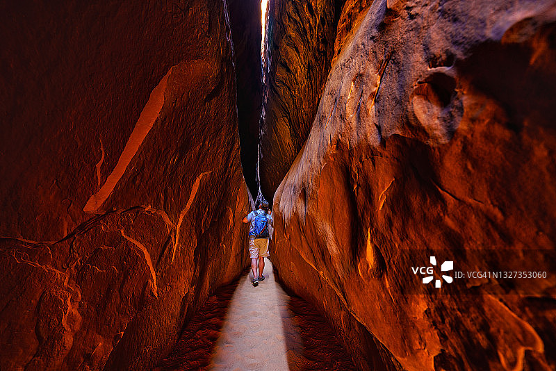 男人在狭窄的峡谷中徒步旅行图片素材