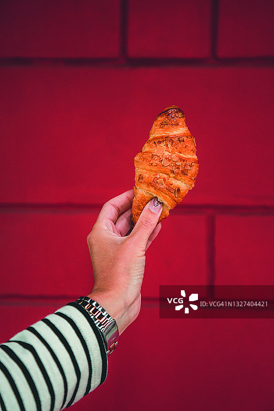 女人手拿牛角包图片素材