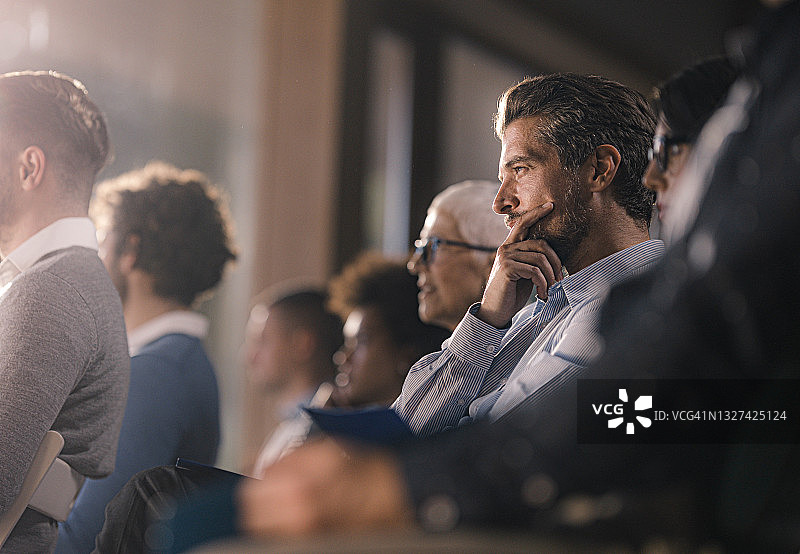 沉思的商人在会议室与同事一起参加研讨会图片素材