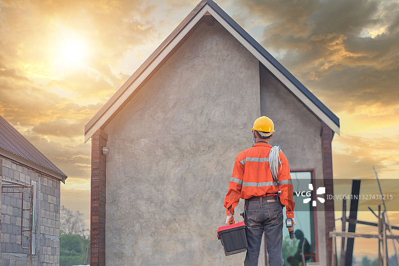 站在泰国新建房屋前的建筑工人图片素材