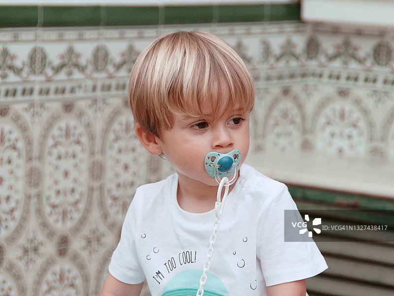 嘴里含着奶嘴的男孩肖像图片素材