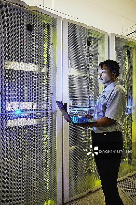 女性IT专业人员在数据中心使用笔记本电脑维护服务器图片素材
