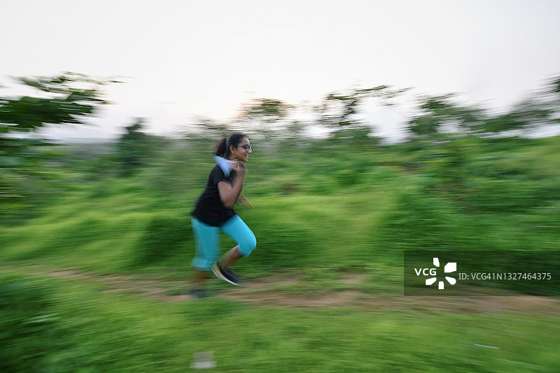 女孩在山丘的道路上跑步图片素材