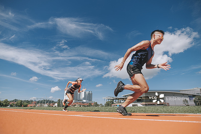 在田径场冲刺的华人运动员图片素材