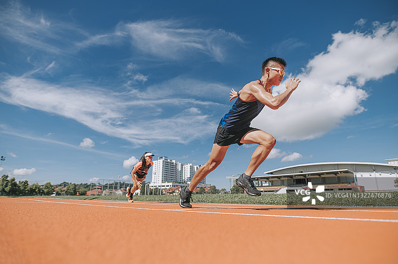 在田径场冲刺的华人运动员图片素材