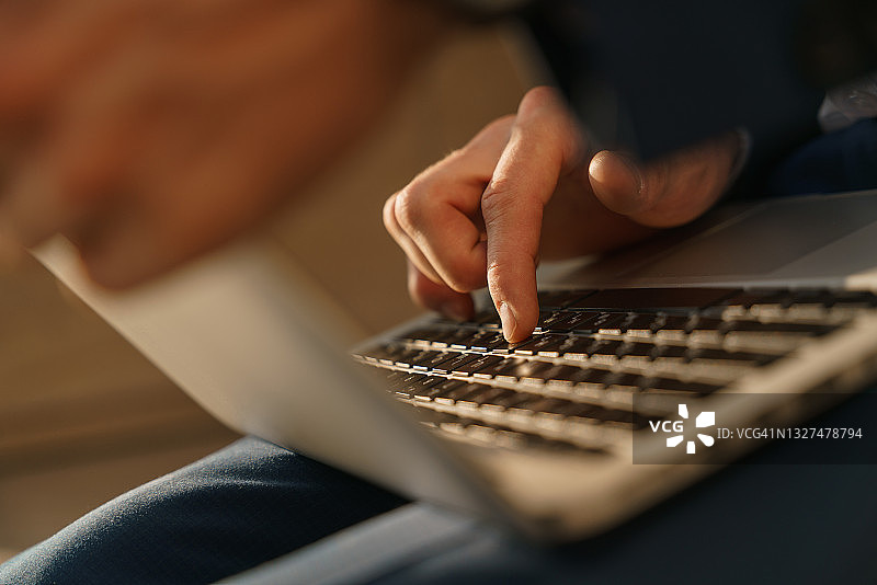 银色笔记本电脑键盘特写，男人正在打字图片素材