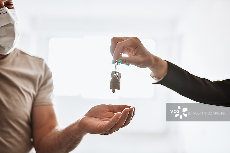 戴口罩的男人拿到新房钥匙，决定购买图片素材