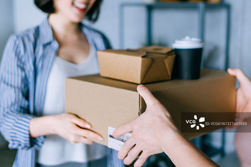 快乐的亚洲年轻女人在家接收外卖订单特写图片素材