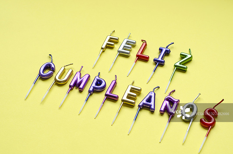 黄色背景上的彩色生日蜡烛，生日快乐图片素材