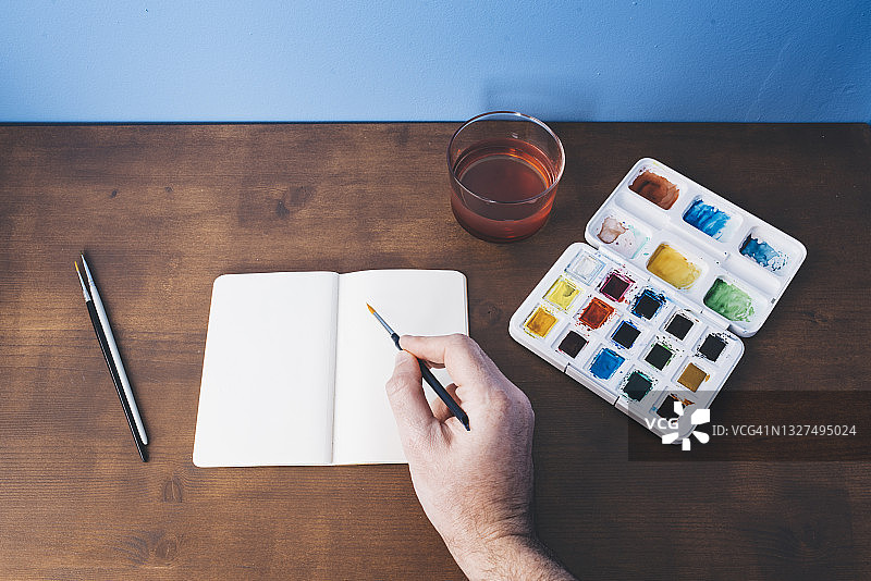 白人手持水彩笔进行绘画创作（俯视图）图片素材