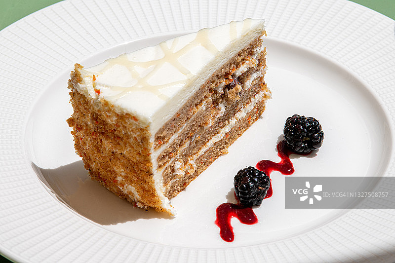 白色盘子上配有黑莓的胡萝卜蛋糕切片图片素材