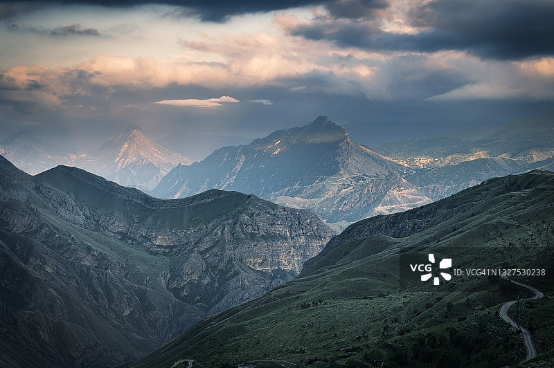 高加索山脉壮丽的山峰，达吉斯坦多云天空下的绿色山丘和蓝色山脉图片素材