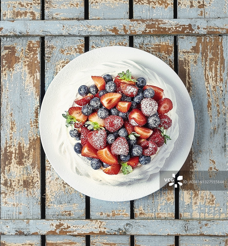 蓝色木质背景上的蛋白甜点图片素材