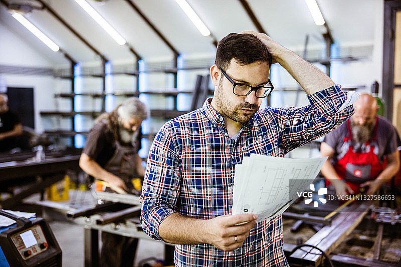 在金属车间分析计划的焦虑工头图片素材