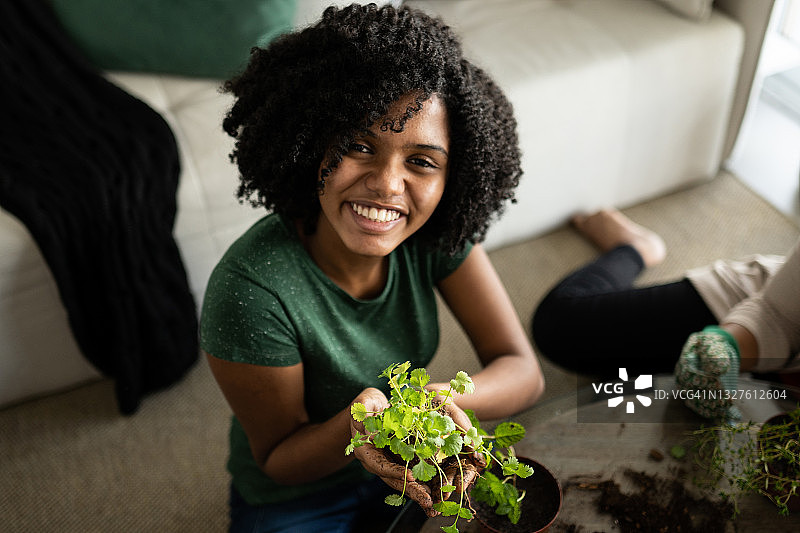 在家 holding a plant 的少女肖像图片素材