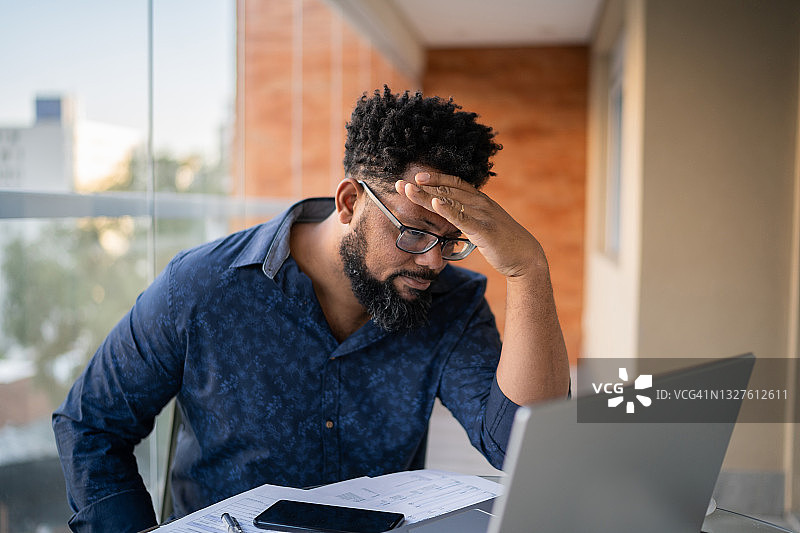 担忧的男人在家分析财务账单图片素材