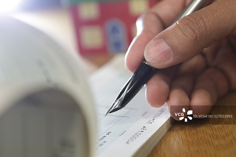 书写支票，背景是模型房图片素材