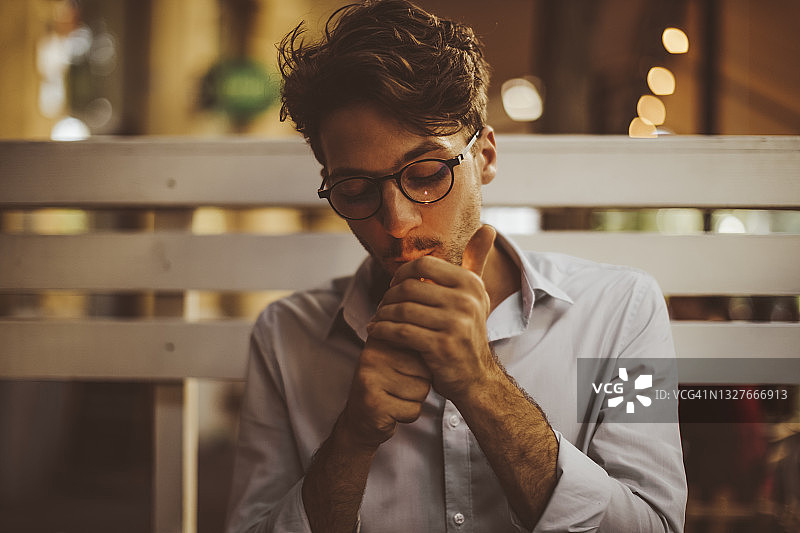 在路边咖啡馆吸烟的年轻男人图片素材