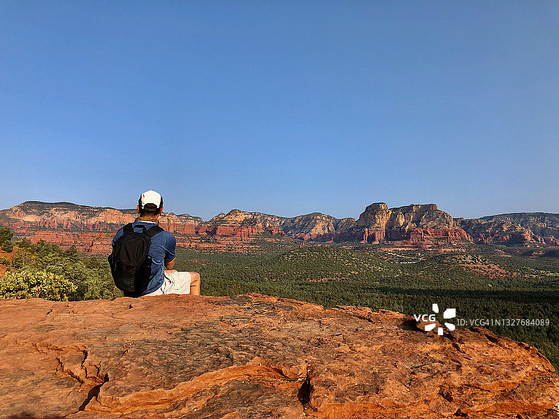 坐在山顶上的男性徒步旅行者图片素材