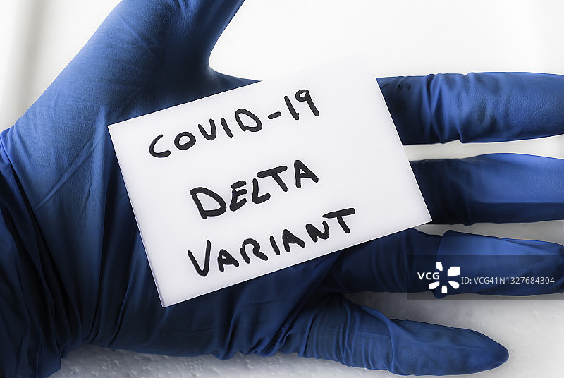 戴着外科手套的手拿着写有“新冠病毒Delta变种”字样的标牌图片素材