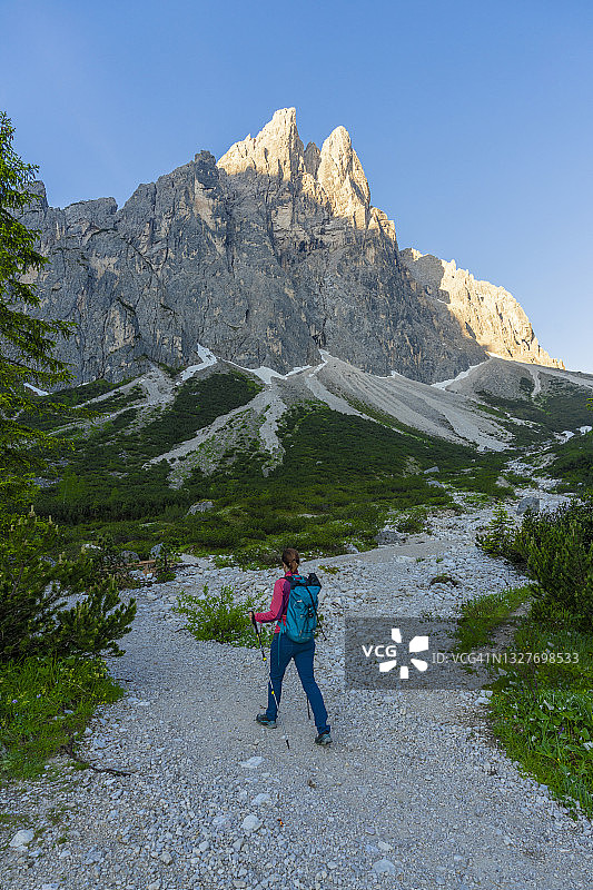日出时在南蒂罗尔多洛米蒂山脉小路上的徒步旅行者图片素材