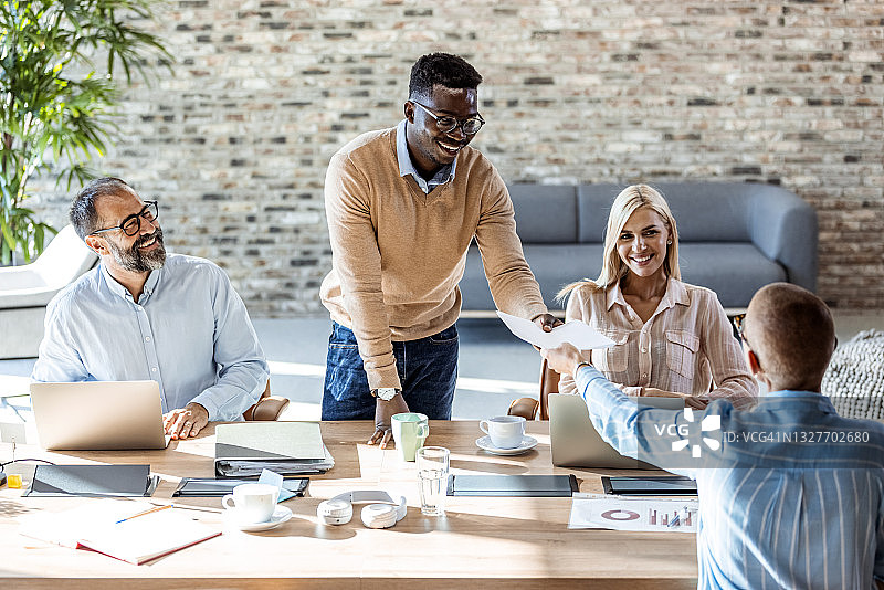 千禧一代商人于演示期间向团队成员分发资料图片素材