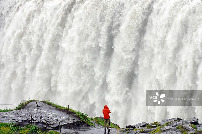 男子站在黛提瀑布前，冰岛图片素材