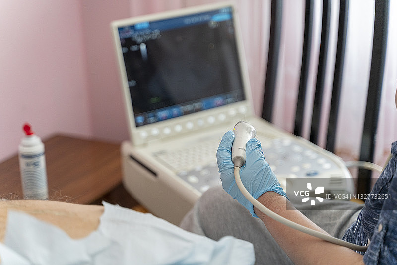 护士使用便携式超声波仪器为97岁老年男性患者在家中进行超声波内脏器官检查和诊断图片素材