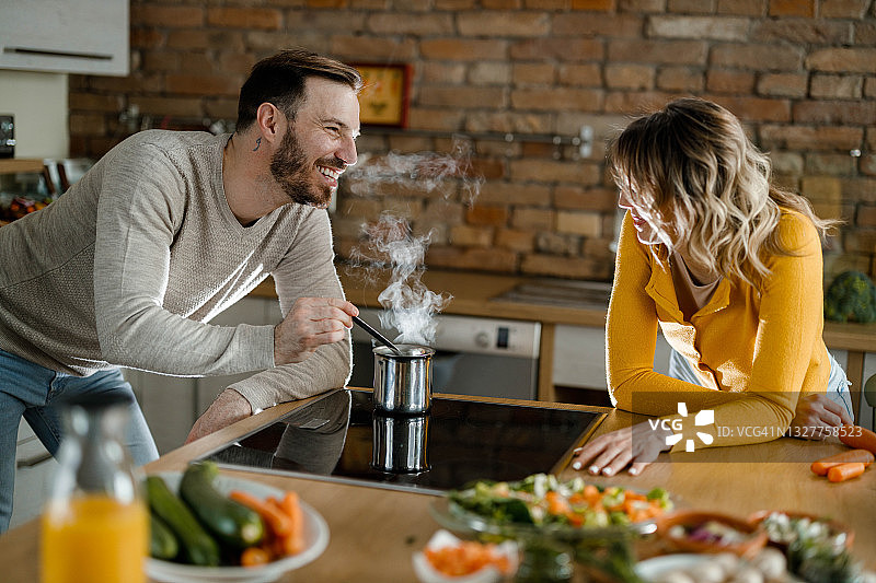 幸福的夫妇在厨房愉快交谈图片素材