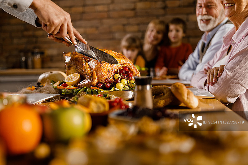为感恩节家庭午餐雕刻火鸡图片素材
