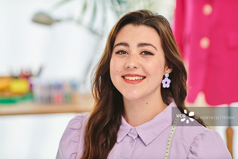 工作室里自信快乐的时装设计师的肖像图片素材