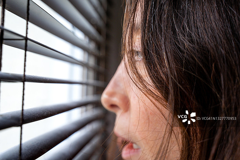 在窗户边的害怕女人图片素材