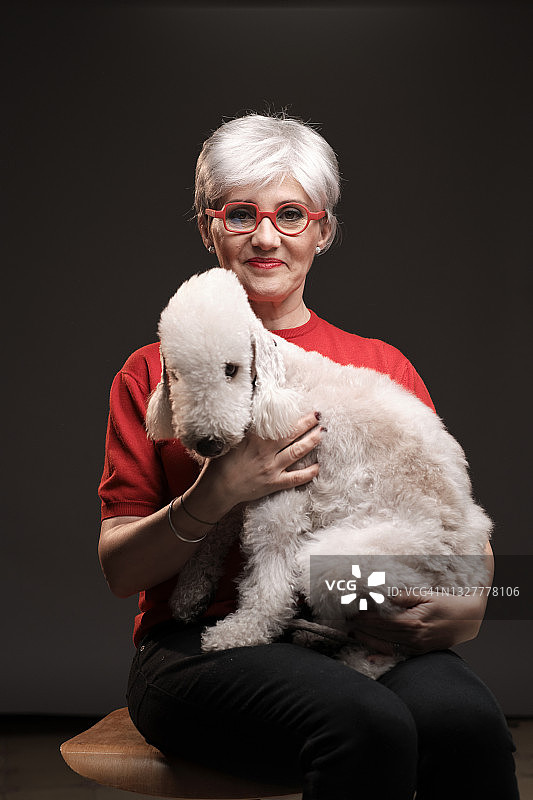 抱着宠物狗的中年妇女肖像图片素材