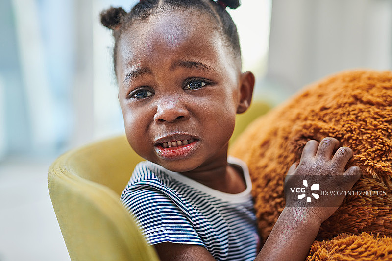可爱的小女孩在医生诊室的候诊室里哭泣图片素材