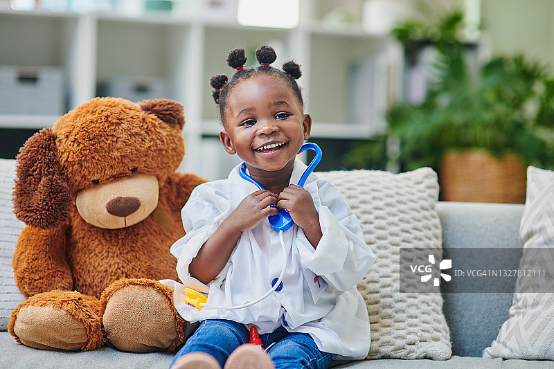 可爱的小女孩在诊所候诊室玩听诊器图片素材