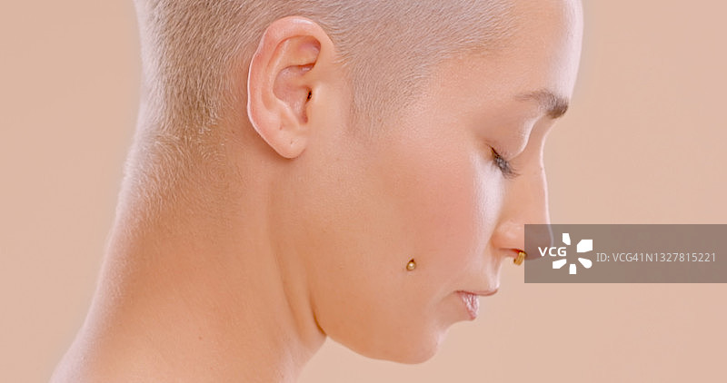 美丽的年轻女子站在桃色背景前的摄影棚照图片素材