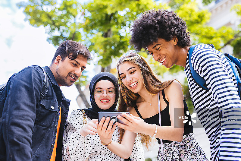 一群千禧一代的朋友用智能手机查看热门视频图片素材