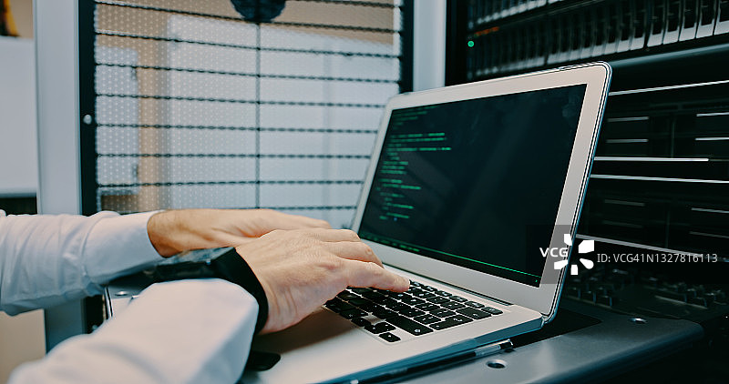 男子在服务器机房使用笔记本电脑图片素材