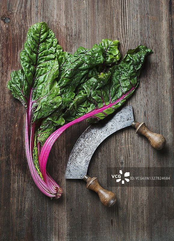 烧焦的食材和月牙刀放在木质表面上图片素材