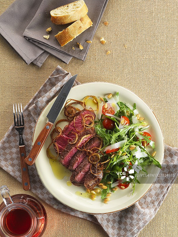 配烤洋葱和芝麻菜沙拉的牛排图片素材