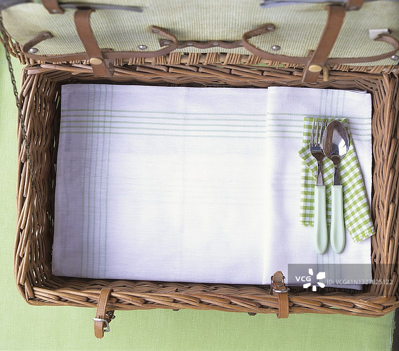 打开的野餐篮、餐具和茶巾图片素材